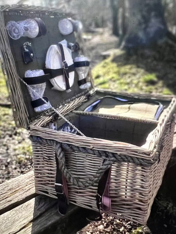 Elegant green tartan picnic hamper with china plates, wine glasses, and stylish leather straps