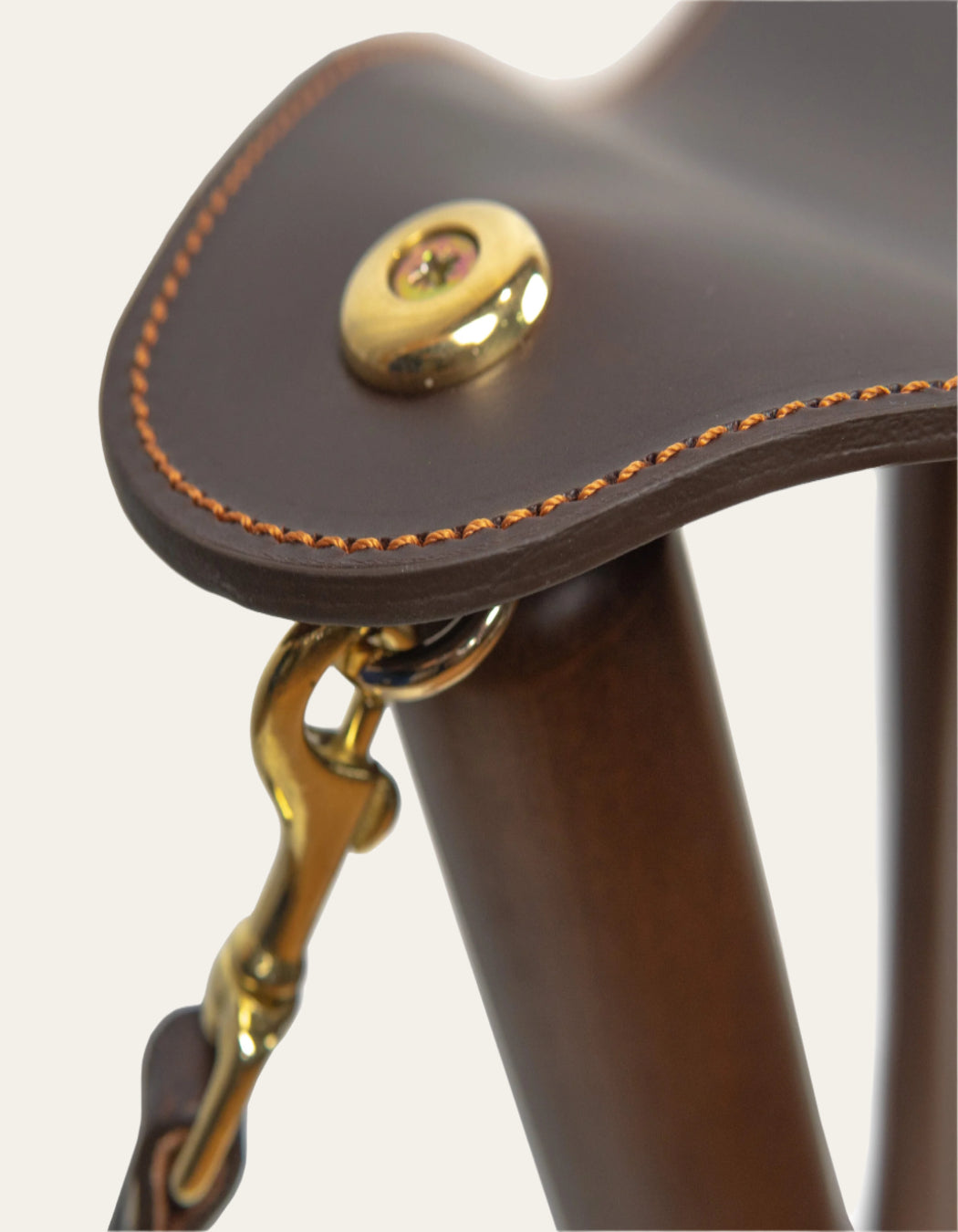 Chocolate-colored cowhide leather tripod stool with durable beech wood poles, ideal for outdoor use